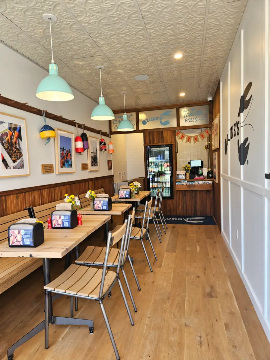 After commercial food service renovation by YESCO Construction Co. in Astoria, New York, featuring updated wood flooring, custom seating, and interior finishes.